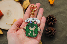 Cargar imagen en el visor de la galería, Llavero de Mossy "Se verde" (Go green) (con purpurina)