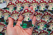 Load image into Gallery viewer, Sticker of mycota sitting on a log
